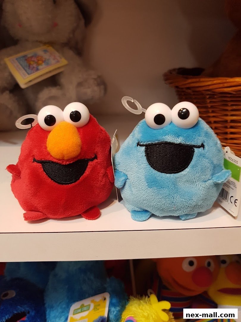 Two plush Sesame Street characters, Elmo and Cookie Monster, displayed on a shelf.