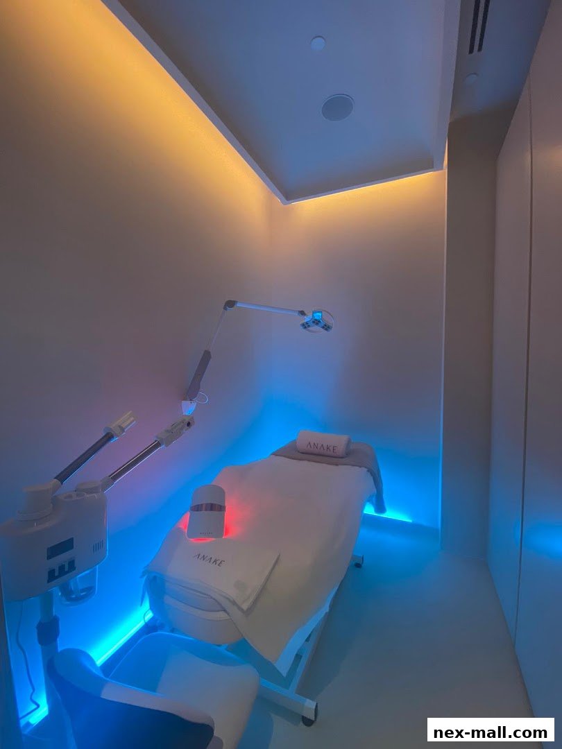 A treatment room with a massage bed, facial steamer, and colored mood lighting.