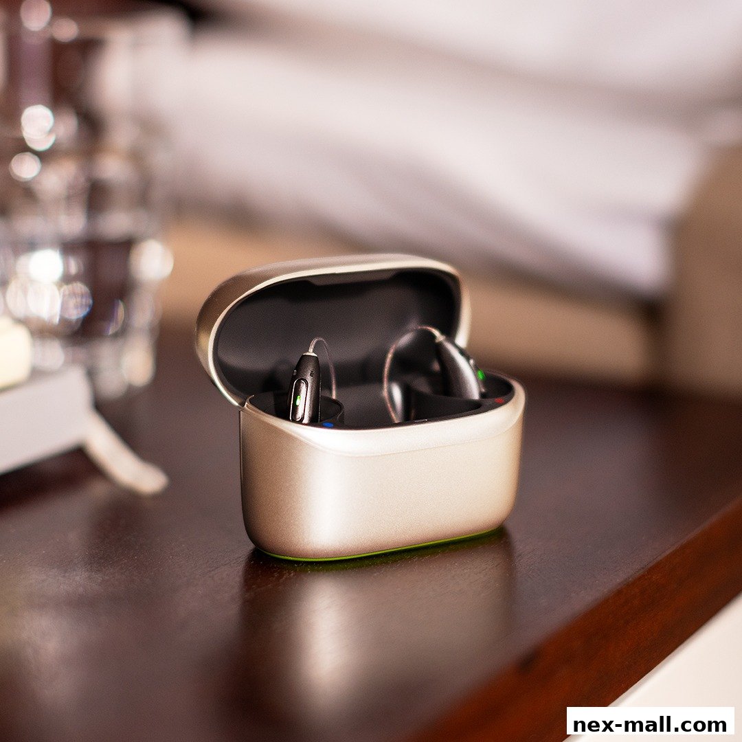 A pair of modern hearing aids in a charging case on a wooden surface.