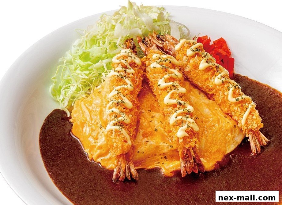 A plate of Japanese curry with fried shrimp, omelet, and shredded cabbage.