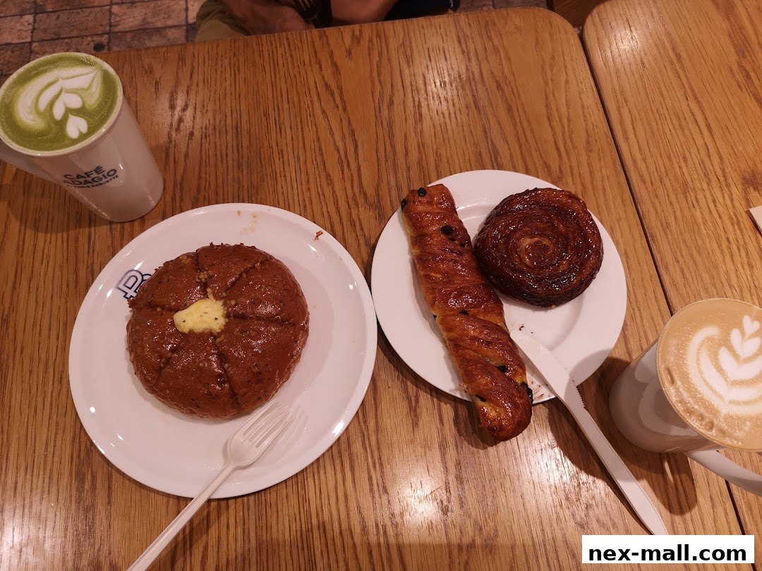 A table with pastries and coffee drinks, including a matcha latte and a cappuccino.