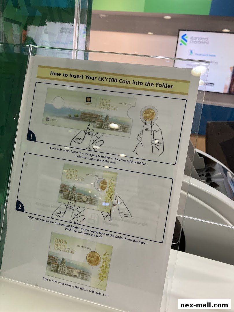 Instructions on how to insert a coin into a folder, with a Standard Chartered Bank logo in the background.