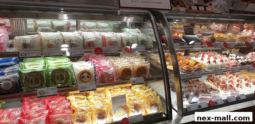 A display case filled with various Japanese cakes, pastries, and mochi treats.