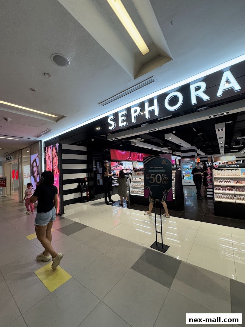 The entrance of a Sephora store with illuminated signage and displays of beauty products.