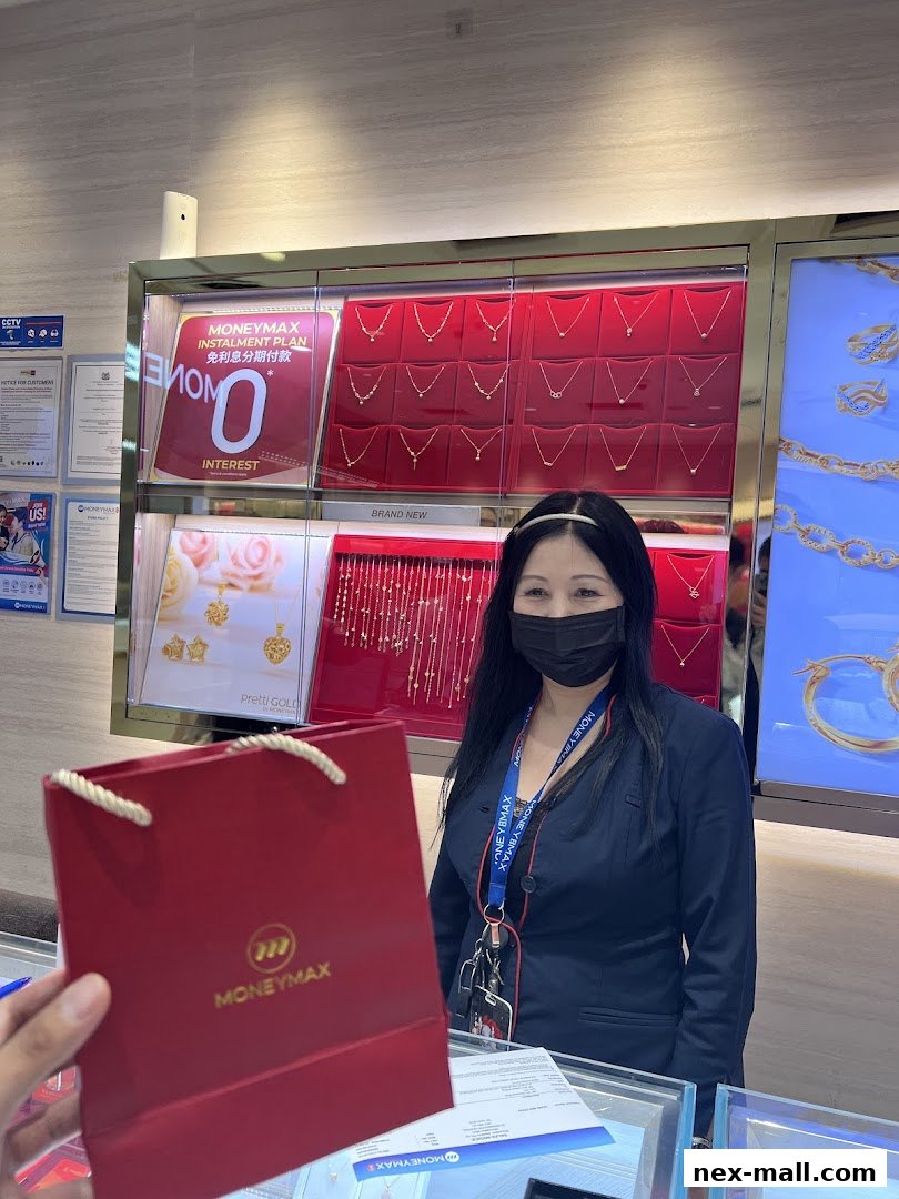 A woman in a dark suit stands behind a counter at MoneyMax Pawnshop, holding a red shopping bag.