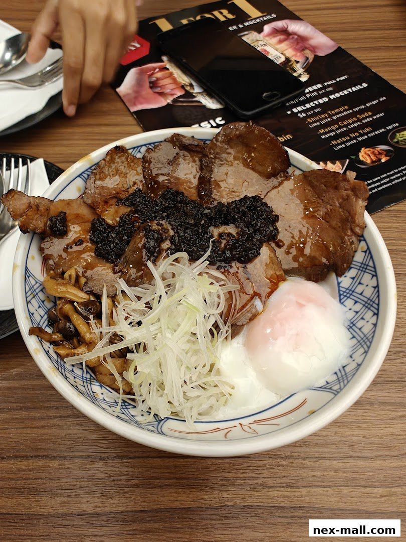A close-up of a delicious Japanese rice bowl with meat, mushrooms, and a soft-boiled egg.