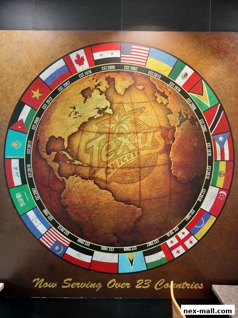 A wall mural featuring a globe surrounded by flags and the Texas Chicken logo.