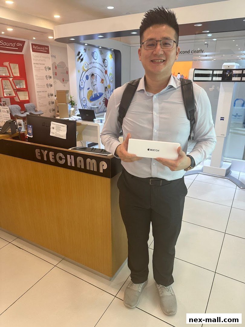 A man holds an Apple Watch box in front of the EyeChamp optical shop counter.