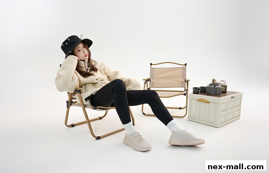 A woman in a fleece jacket and hat sits in a camping chair with outdoor gear.