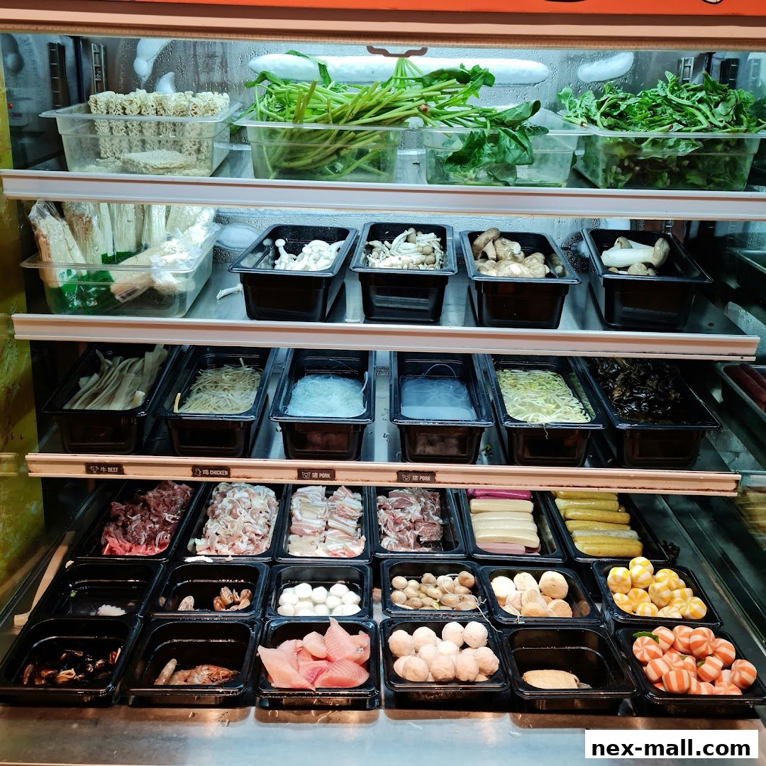 A display of fresh ingredients for Mala Tang, including vegetables, mushrooms, meats, and seafood.