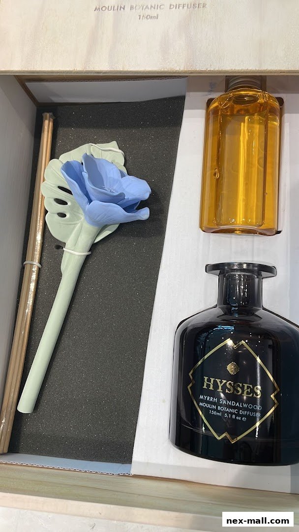 A HYSSES Myrrh Sandalwood diffuser set with a decorative blue flower and reeds.