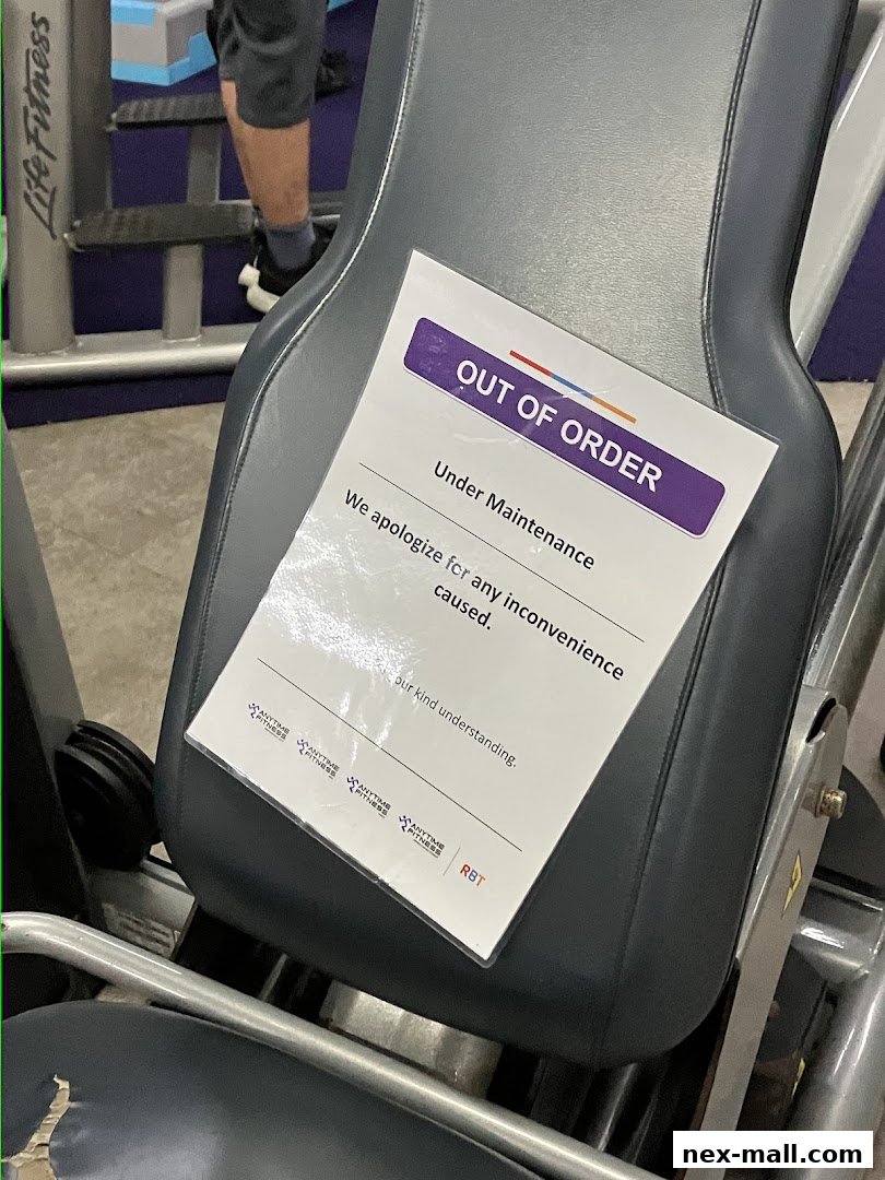 A gym machine with an 'Out of Order' sign indicating it is under maintenance.