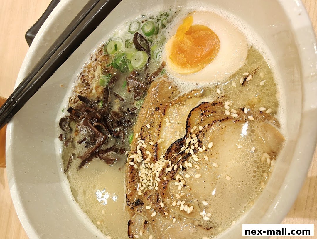 A close-up shot of a delicious bowl of ramen with pork, egg, and green onions.