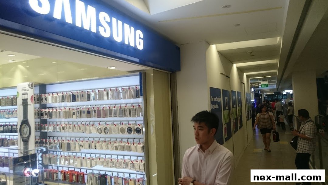 A Samsung phone shop with a display of phone accessories and a young man standing nearby.