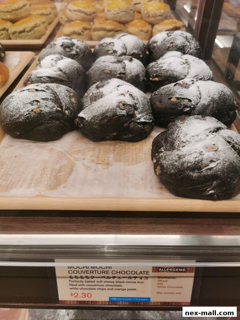 A display of freshly baked black cocoa buns dusted with powdered sugar and nuts.