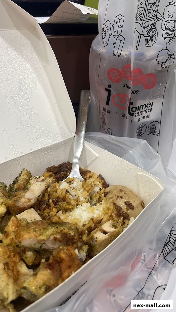A takeout box filled with rice, chicken, and egg, next to a branded drink cup.