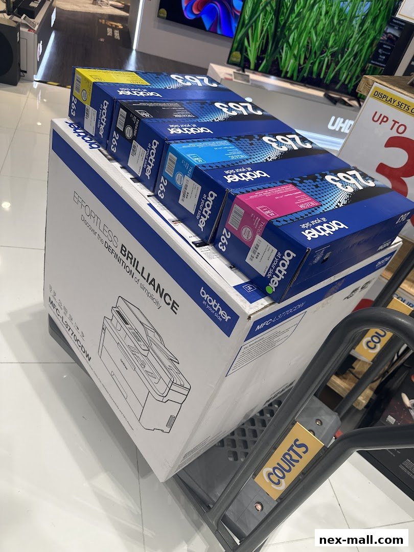 Boxes of Brother printer ink cartridges and a printer are displayed in a retail store.