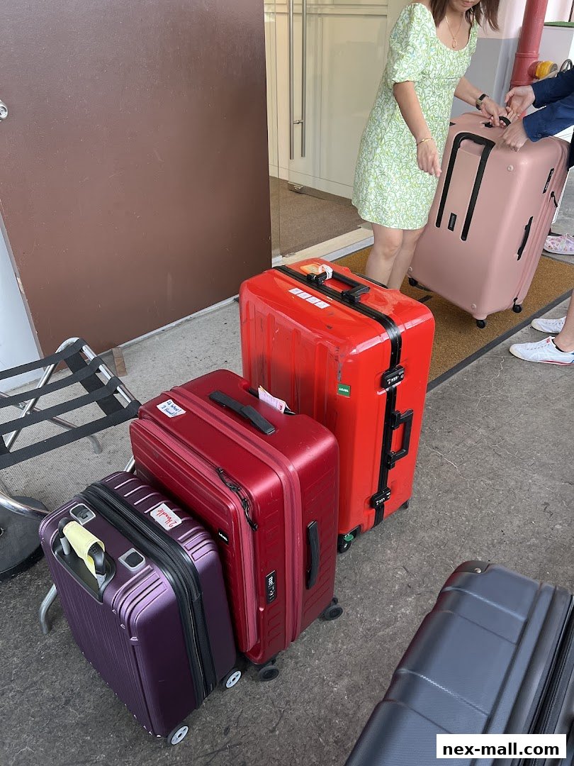 People with various colorful suitcases are gathered outside a store entrance.