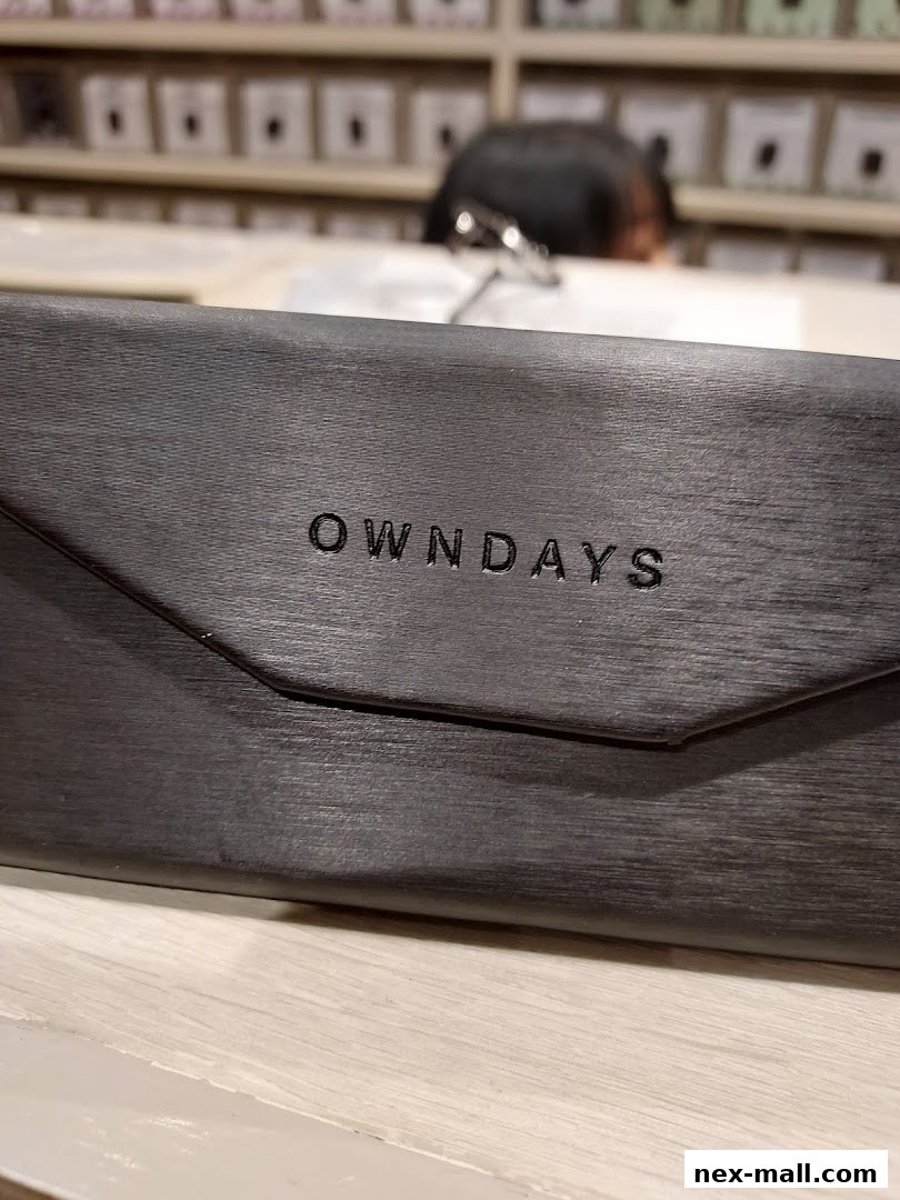 A close-up of a dark grey glasses case with the OWNDAYS logo embossed on it.