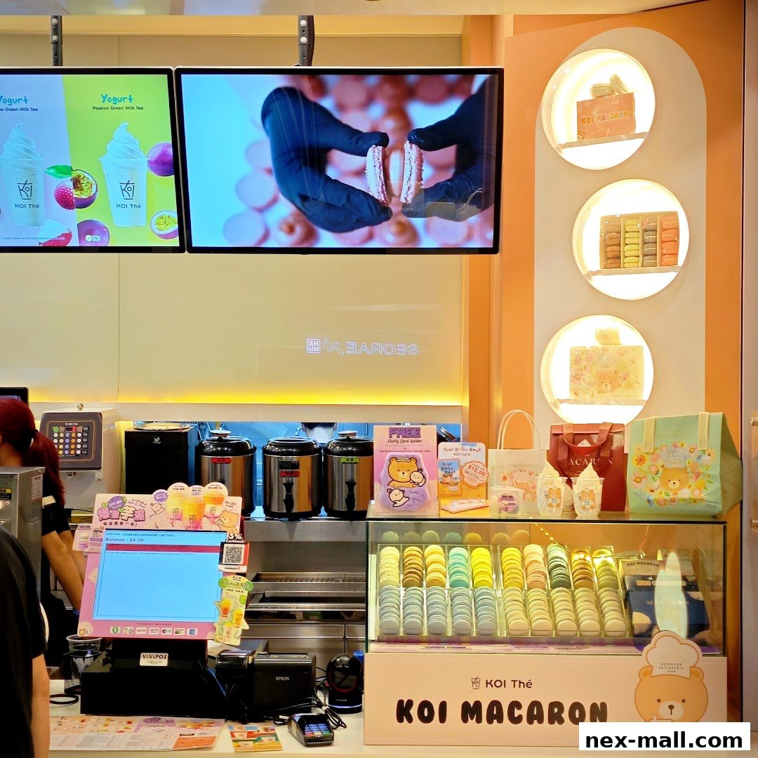 A display of colorful macarons and merchandise at a KOI Thé shop.