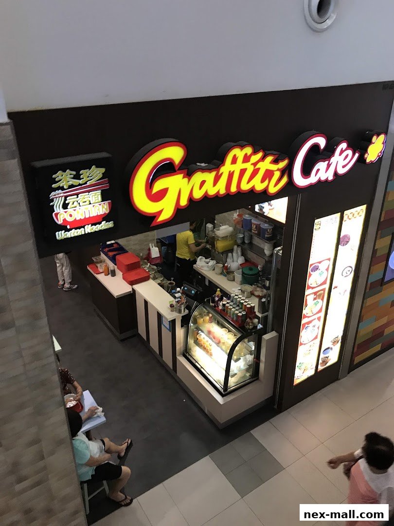 The Graffiti Cafe - NEX shop front with a prominent sign and display of food items.