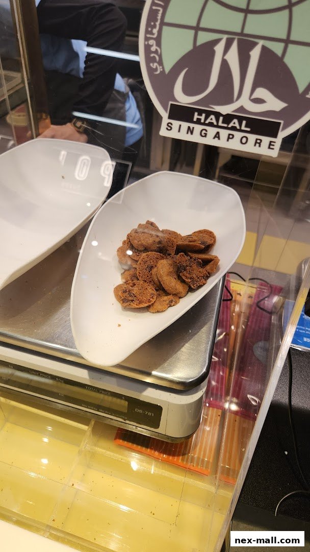 A scale with a bowl of cookies and a Halal Singapore sticker.