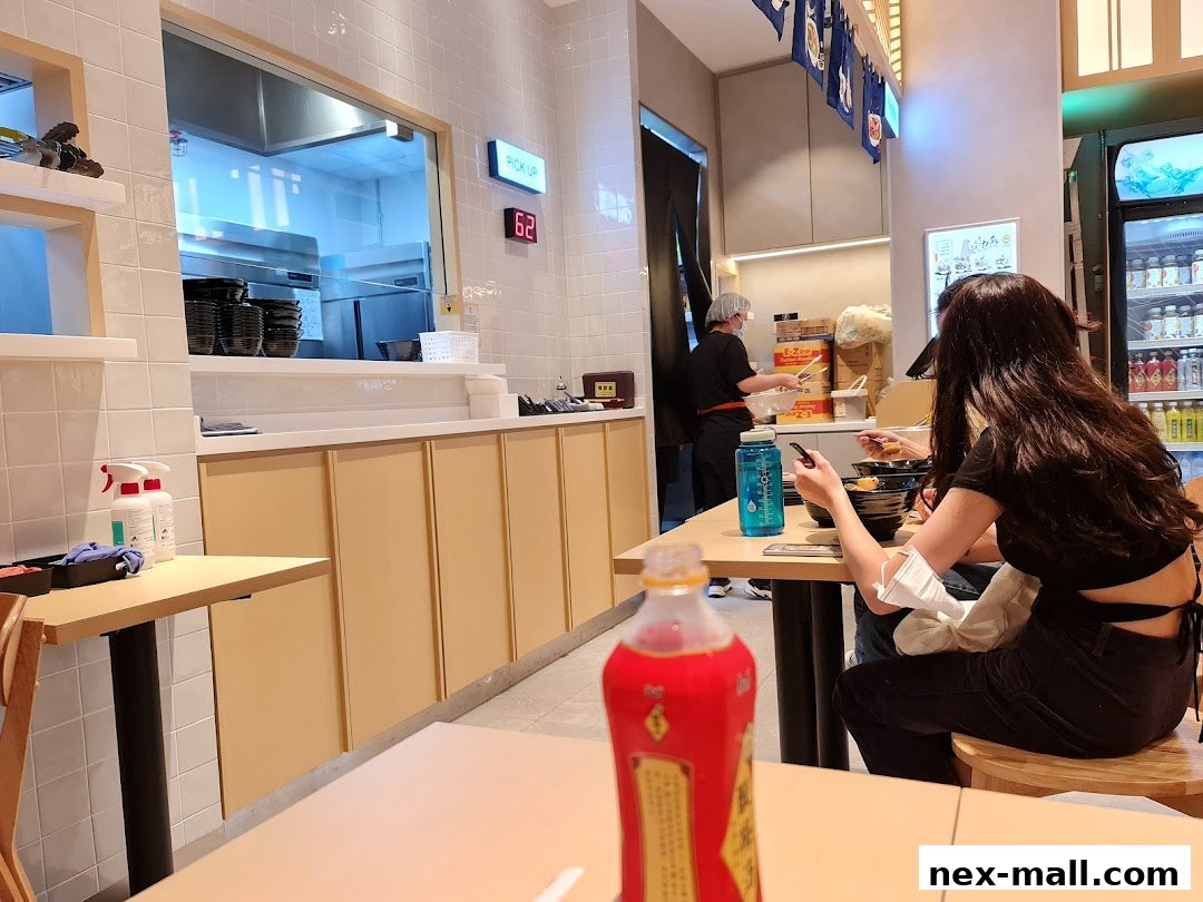 Diners enjoy a meal at Gong Yuan Ma La Tang, with a view of the kitchen and a pickup counter.