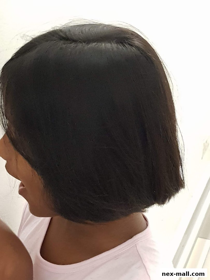 A young girl with a fresh bob haircut, smiling.