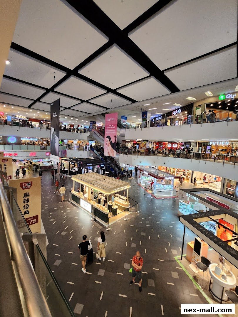 A wide shot of a busy shopping mall interior with multiple levels and shops.