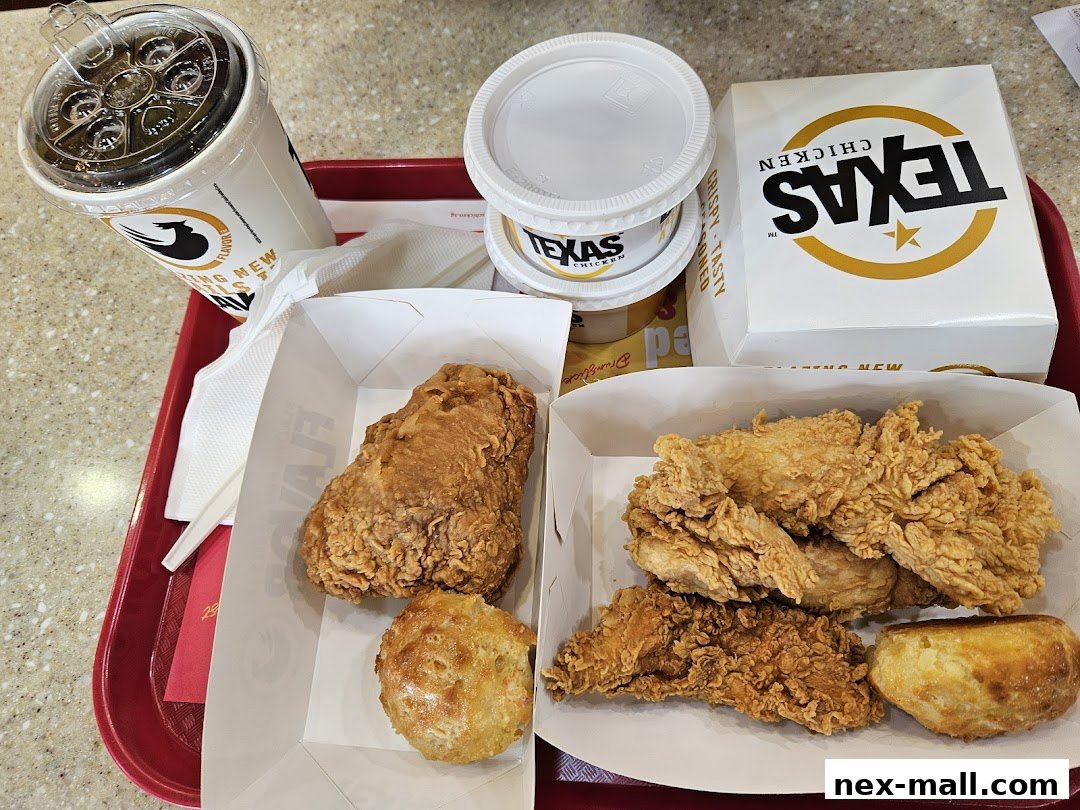 A tray of Texas Chicken food including fried chicken pieces, biscuits, and a drink.