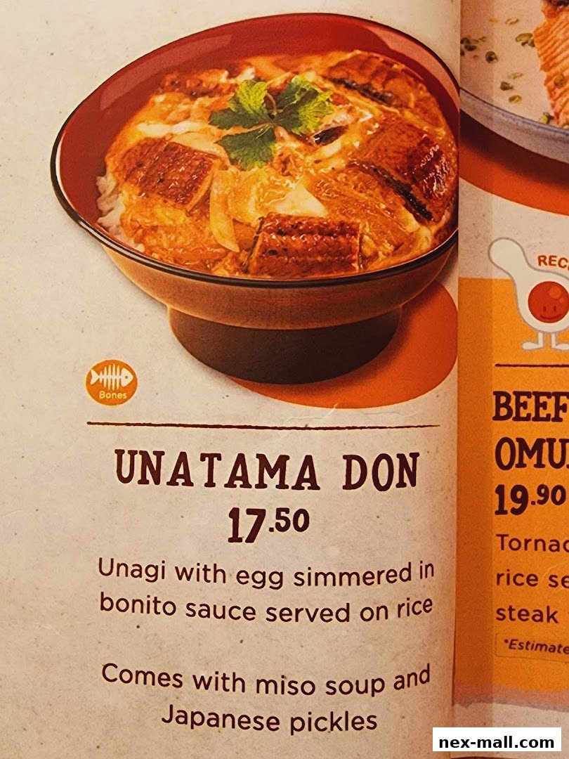 A close-up of a delicious Unatama Don dish with eel, egg, and sauce on rice.