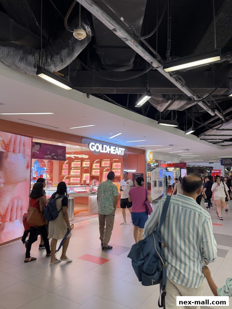 People walking past a Goldheart Jewelry store in a mall.
