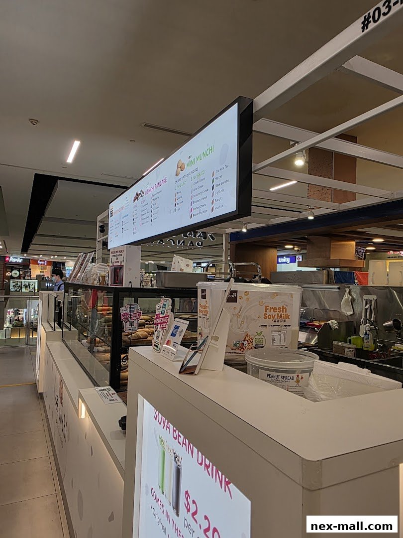 A food stall counter with a digital menu displaying pancakes and drinks.