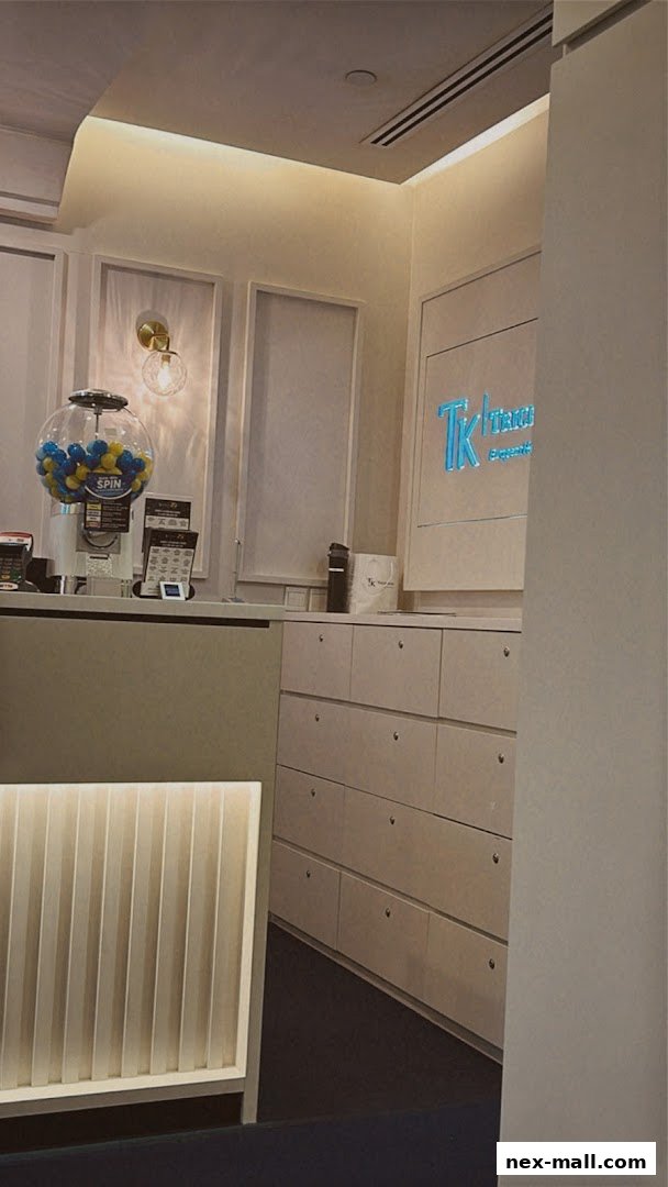 Interior view of TK TrichoKare, showing a reception desk with a gumball machine and the shop's logo.