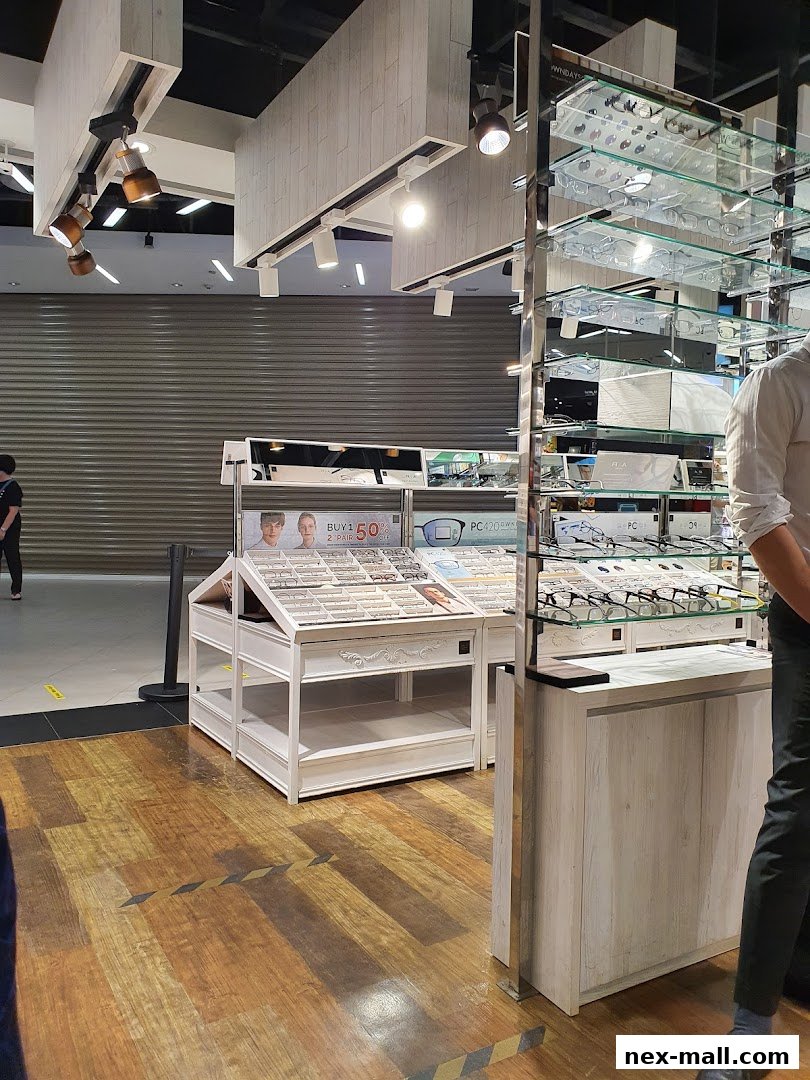 Interior shot of an eyeglasses store with displays of glasses and a promotional sign.