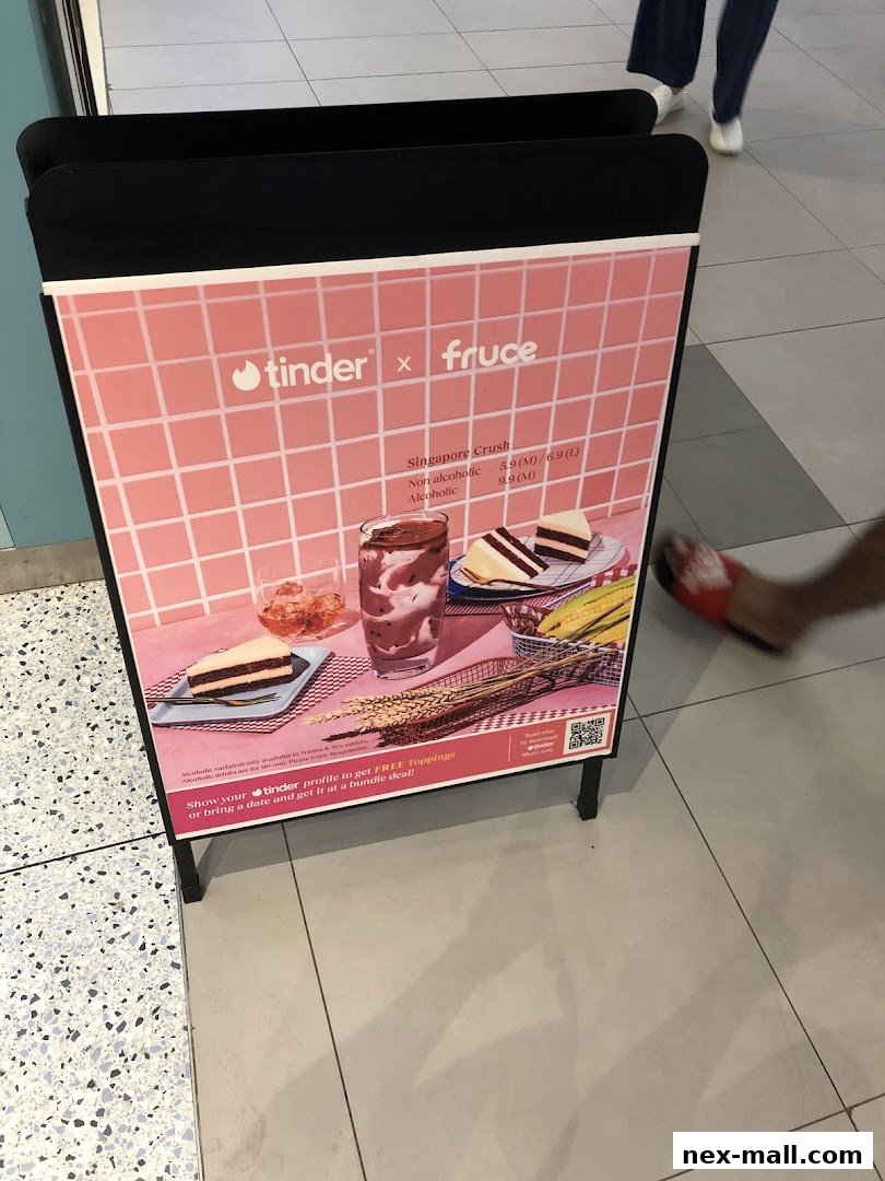 A promotional stand for Fruce and Tinder, featuring a drink and cake.