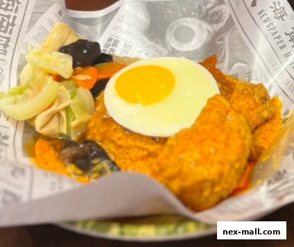 A close-up of a delicious meal featuring fried chicken, a sunny-side-up egg, and mixed vegetables.