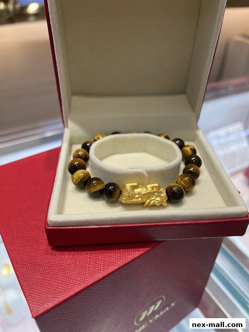 A tiger's eye stone bracelet with a gold charm in a red gift box.