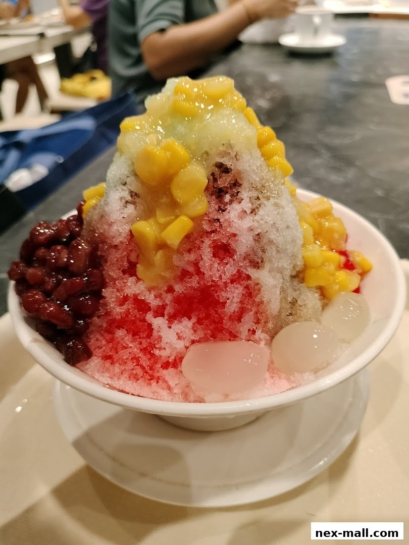 A refreshing bowl of shaved ice dessert with red beans, corn, and jelly.