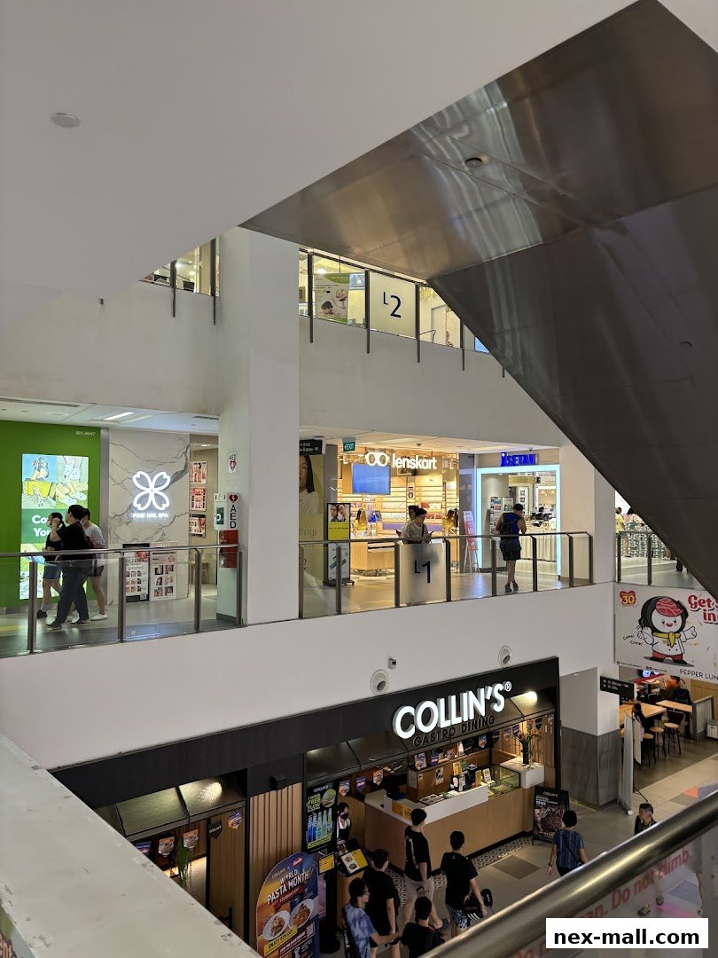 A view of a shopping mall interior with various shops including Lenskart and Collin's Gastro Dining.