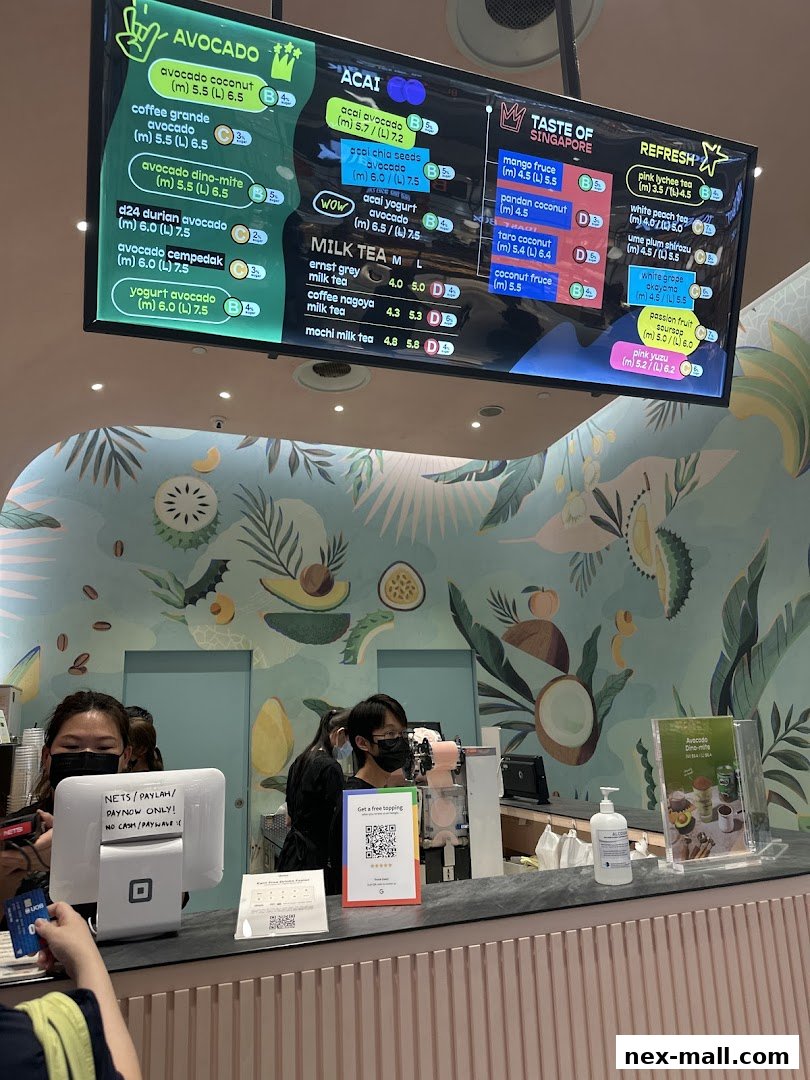 A digital menu board displaying various avocado, acai, milk tea, and refresh drinks with prices.