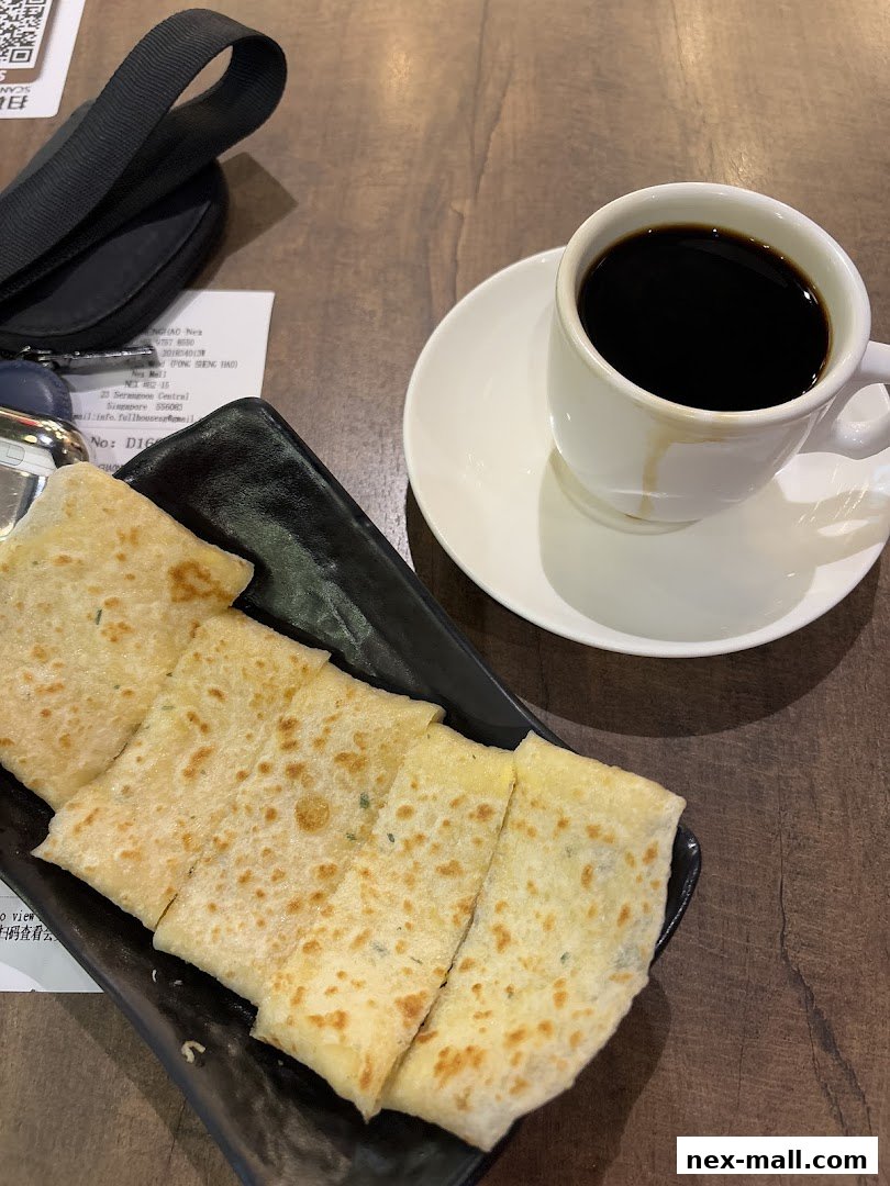 A plate of savory scallion pancakes served with a cup of black coffee.