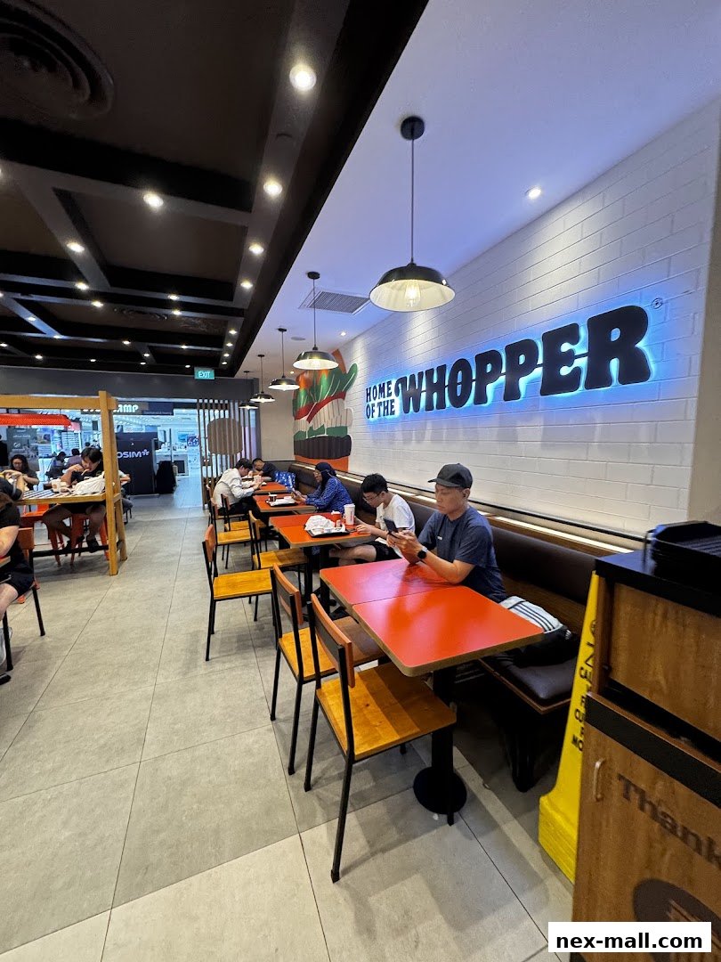Interior view of a Burger King restaurant with customers dining at tables.