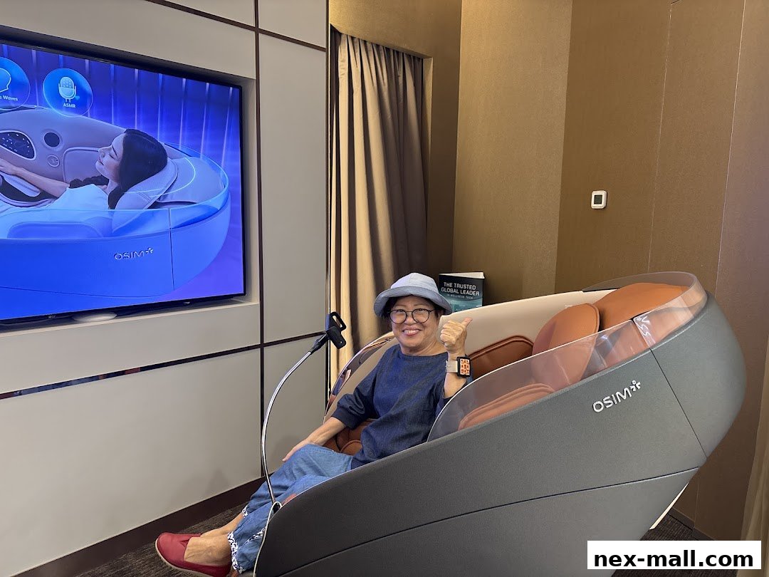 A person sits in an OSIM massage chair, giving a thumbs up, with a promotional screen in the background.