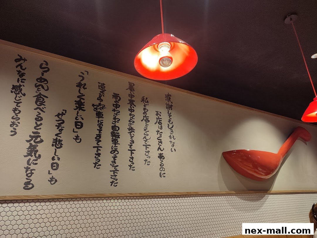 A wall with Japanese calligraphy and a large red ladle decoration.