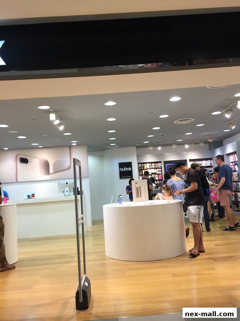 Customers browse Apple products at the iStudio NEX store.