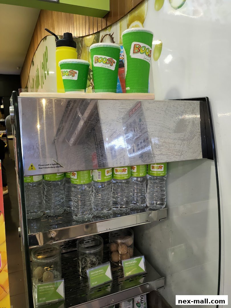Boost Juice NEX display featuring branded cups, water bottles, and protein balls.
