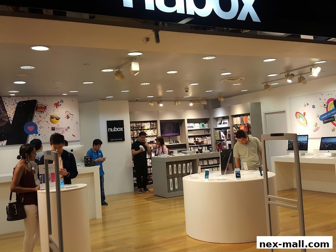 Customers browse Apple products inside a brightly lit iStudio NEX store.