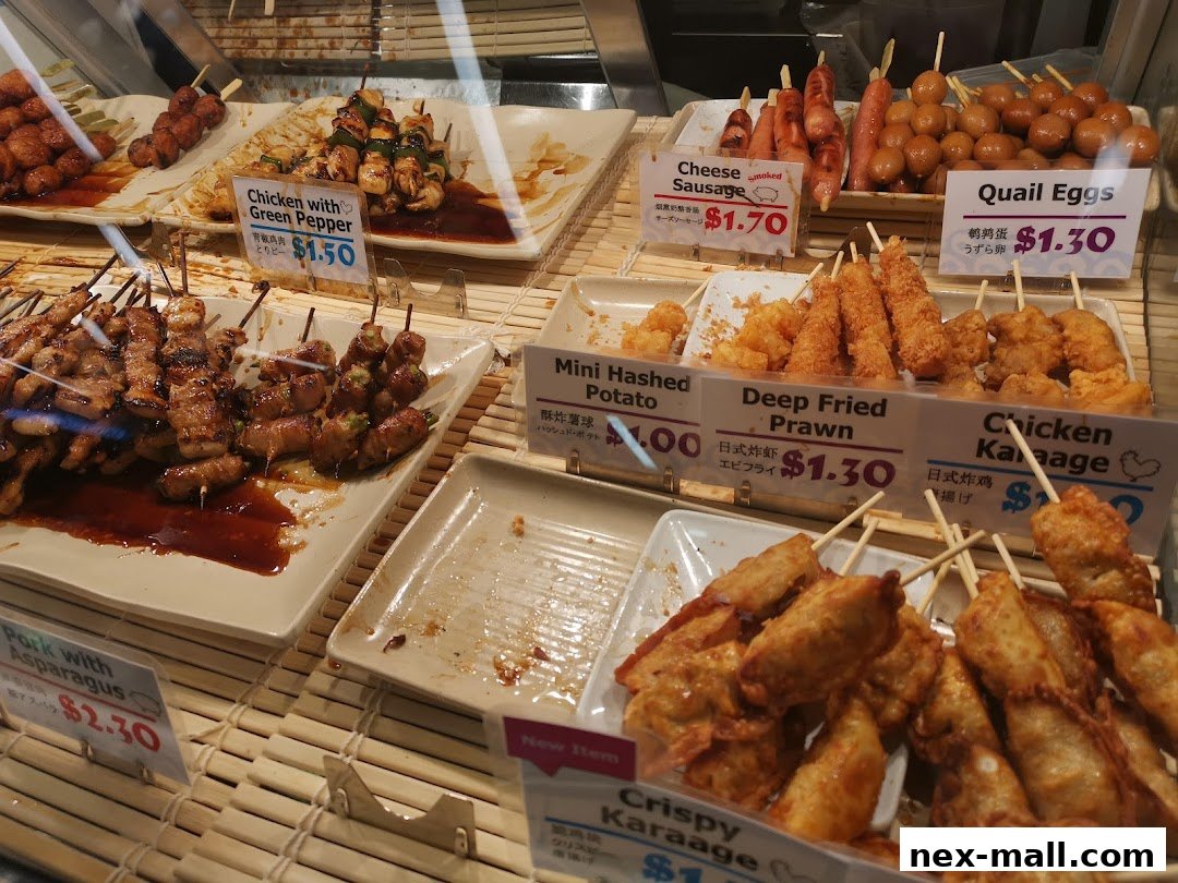 A display of various Japanese skewers and fried items, including chicken, pork, sausages, and seafood.