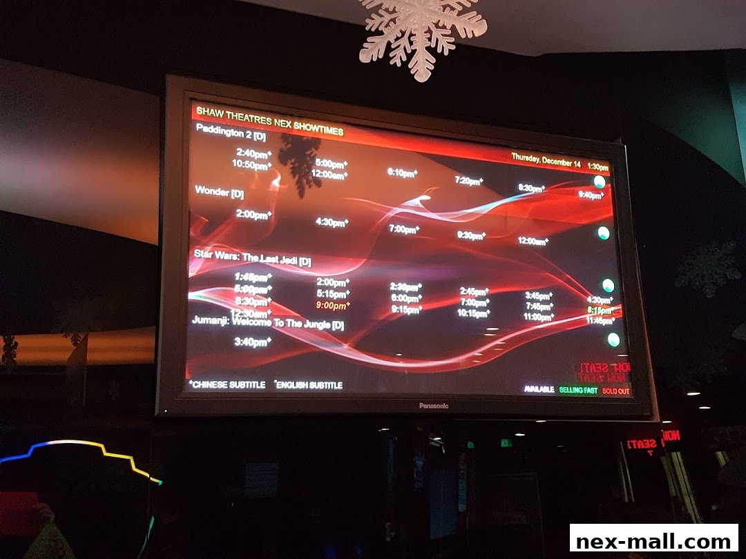 A digital display showing movie showtimes for Shaw Theatres NEX.